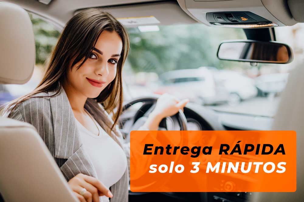 A woman behind the wheel is happy because Caraveando car hire in Castelldefels delivers the vehicle in just 3 minutes.