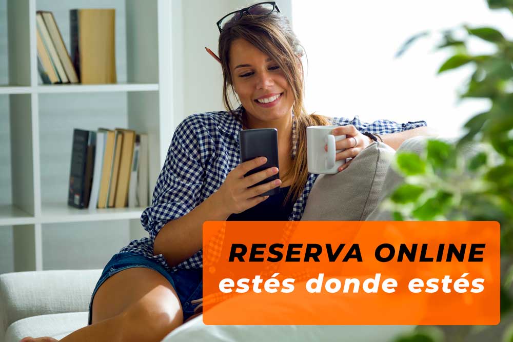 A girl sitting on the sofa with a smartphone in her hand, booking at Caraveando, car hire in Castelldefels.