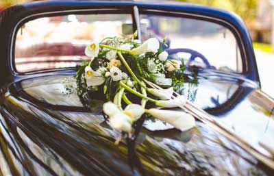 Flores blancos sobre el capo de un coches para boda alquilado en barcelona