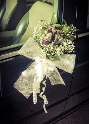 Ejemplo de moño y flores en un coche de alquiler para bodas en Barcelona