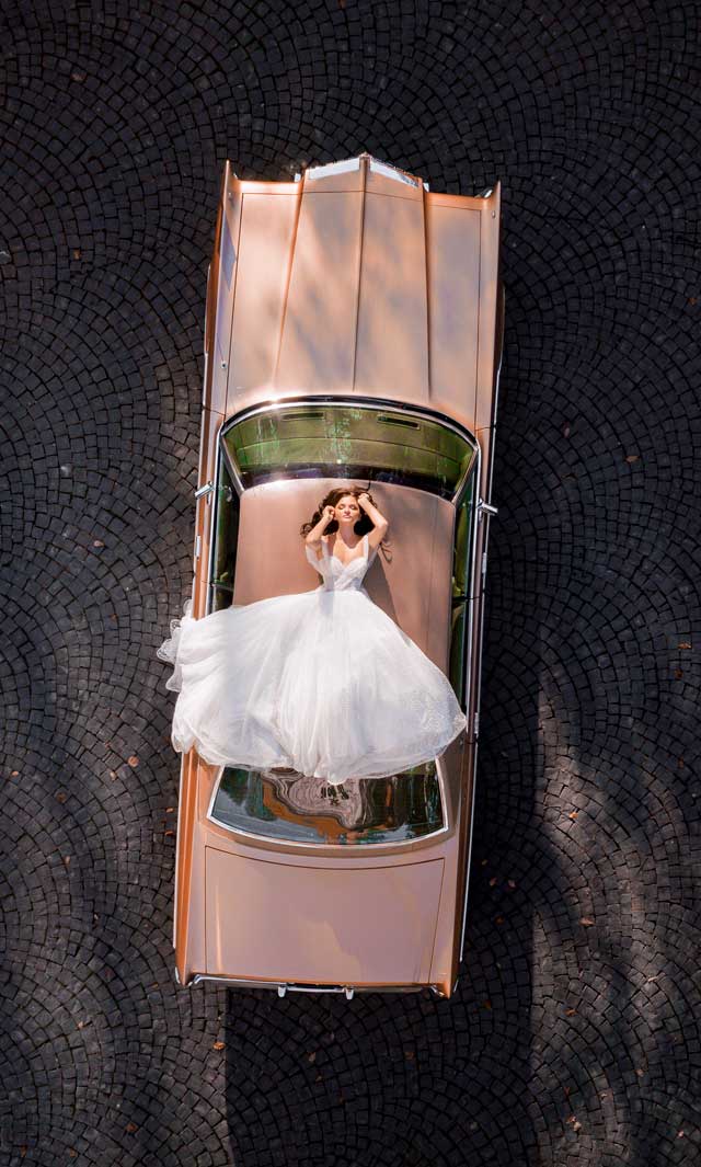 Una novia tumbada en el techo de un coche de alquiler en Barcelona