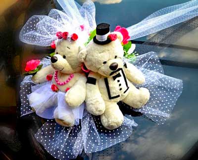 Stuffed animals dressed as bride and groom as decoration of the wedding car rented in Barcelona